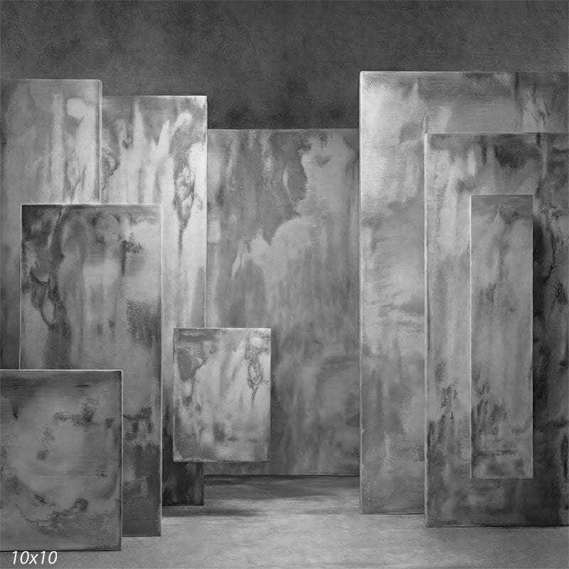 Studio background featuring monochromatic gray plaster-textured rectangular panels arranged with depth for portrait photography.