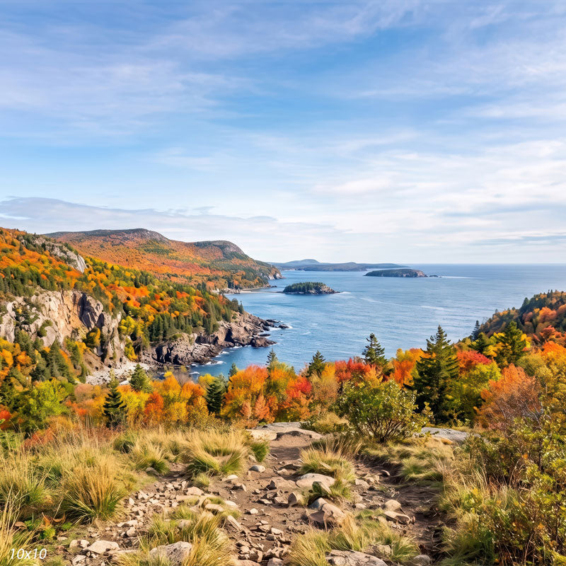 Autumn coastline photography backdrop shown wider, with distant headlands, small islands, and a grassy rocky foreground trail along the cliffs.