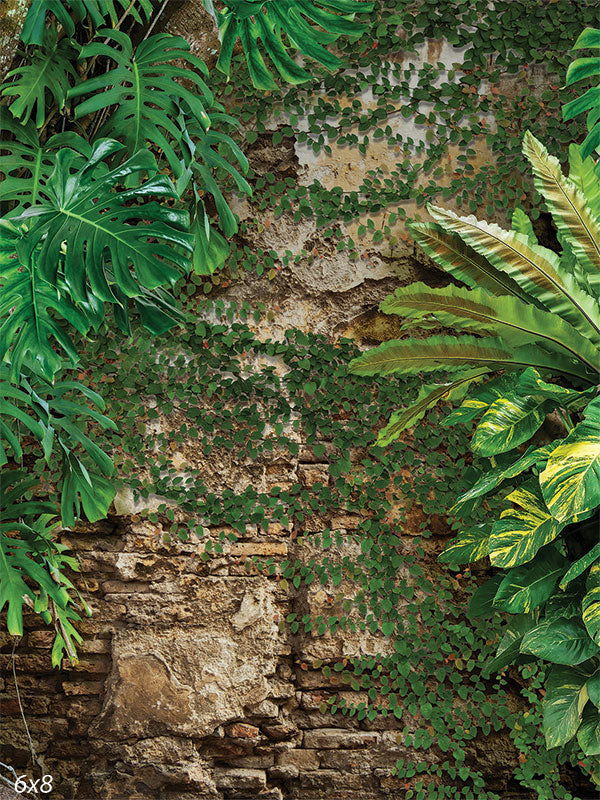 Tropical Greenery Photography Backdrop - Photography backdrop featuring lush tropical plants and greenery against a rustic stone wall.