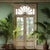 A vintage-style photography backdrop featuring a beautifully weathered double-door with glass panes, framed by lush tropical greenery and palm fronds.