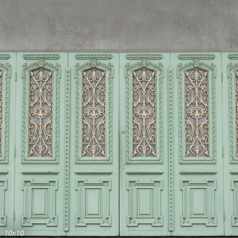 A photography backdrop featuring ornate mint green wood panels and decorative metal scrollwork.