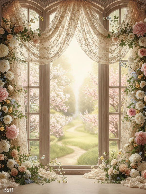 Printed photography backdrop showing arched window panels with lace drapery and a floral arch framing both sides. A soft garden path and blooming trees appear through the window behind a subject.