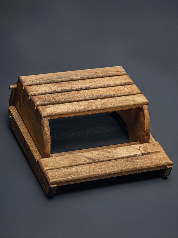 Wooden step stool bench photography prop with a slatted seat and curved sides, shown in an overhead view showing the slatted seat on a plain grey studio background.