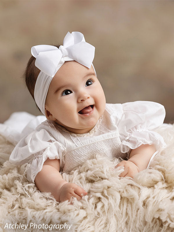 Ansel soft misty meadow with trees photography backdrop shown with a baby with a white bow headband on a cream fur rug, close portrait CP-8845