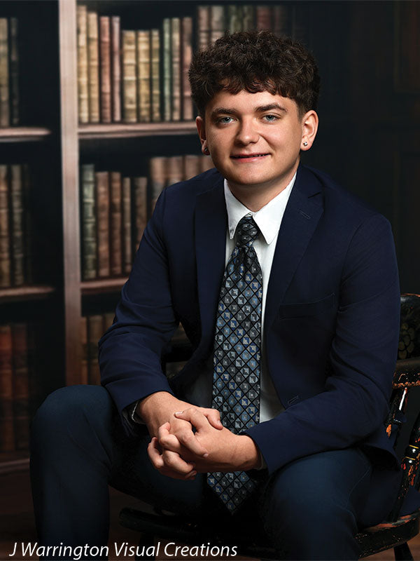 Benedict dark wood library bookcase photography backdrop shown with a senior in a navy suit seated on an antique chair in a three-quarter portrait CP-8839