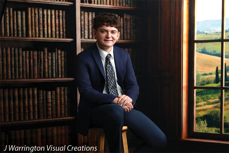 Benedict dark wood library bookcase photography backdrop shown with a senior in a navy suit seated on a stool by the arched window, wide view CP-8839