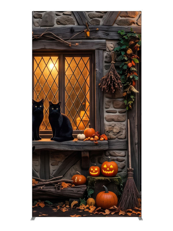 Two black cats on a glowing leaded cottage window in a stone-and-timber wall with jack-o'-lanterns, 4ft photography backdrop panel for Denny StudioEdge silicone edge frame