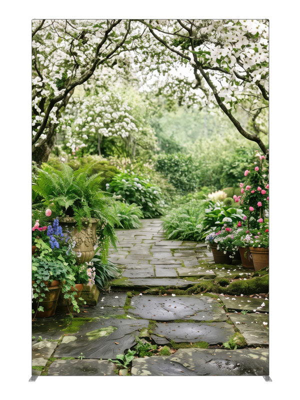 A stone garden path beneath blooming white dogwood trees with ferns, hostas and potted roses, 5ft photography backdrop panel for Denny StudioEdge silicone edge frame