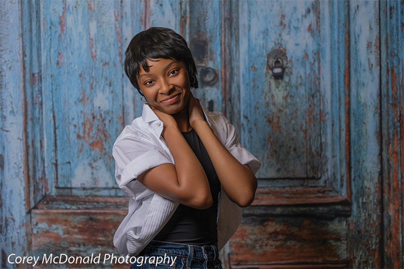 Blue Desire Street, photography backdrop panel for Denny StudioEdge silicone edge frame, shown with a senior girl in a white shirt and denim shorts with a hand at the back of her neck SECP-7654