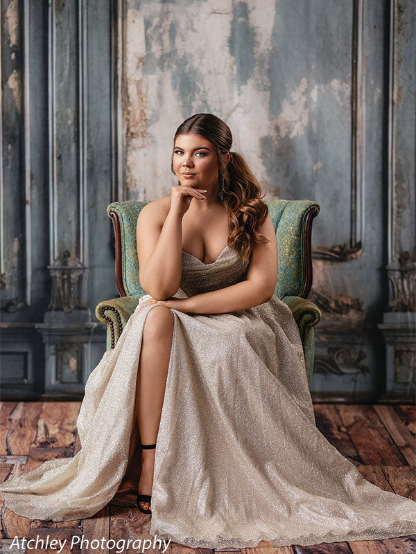 Elegant blue vintage panel backdrop featuring a young woman in a sparkling gold prom dress seated on an ornate chair, perfect for modern glamour portrait photography.