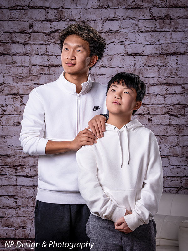 Broadway Brick exposed brick photography backdrop shown with an older brother with his arm around a younger brother by the brick wall CP-7742