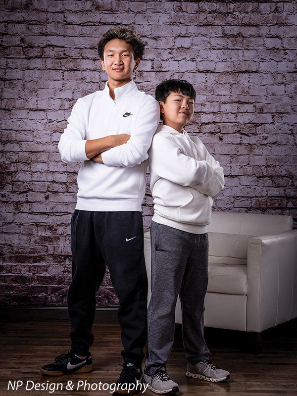 Broadway Brick exposed brick photography backdrop shown with two brothers standing with arms crossed by the brick wall CP-7742