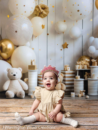 Joyful toddler girl in front of birthday décor featuring balloons, teddy bears, and wrapped presents on the Bears and Stars Cake Smash Backdrop.