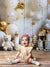 Joyful toddler girl in front of birthday décor featuring balloons, teddy bears, and wrapped presents on the Bears and Stars Cake Smash Backdrop.