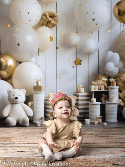 Toddler girl wearing a pink birthday crown, sitting happily among teddy bears and gold-accented decorations on the Bears and Stars Cake Smash Backdrop.
