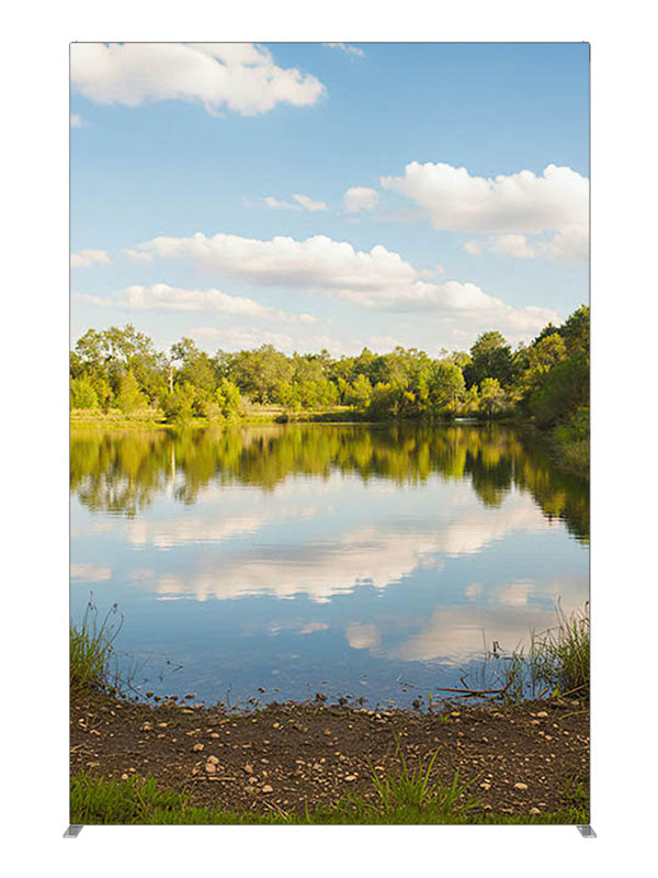 A calm lake mirroring a blue cloud-filled sky with a green tree line and grassy banks, 5ft photography backdrop panel for Denny StudioEdge silicone edge frame