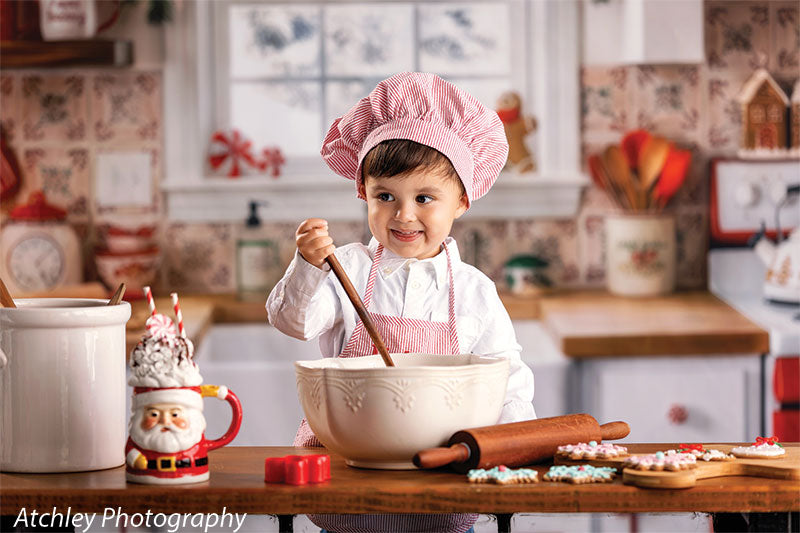 Candy Kitchen retro gingerbread kitchen photography backdrop shown with a young boy in a pink chef hat stirring a bowl and smiling CP-8911