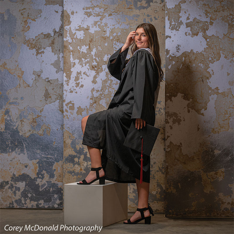 Caspian Silver and Beige Weathered Texture, photography backdrop panel for Denny StudioEdge silicone edge frame, shown with a senior girl in a graduation gown resting a foot on a white posing cube holding her cap SECP-8856