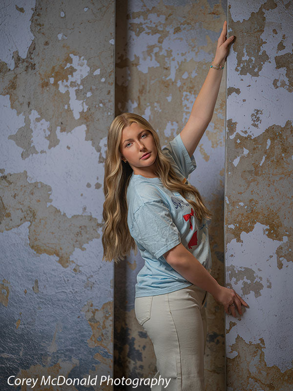 Caspian Silver and Beige Weathered Texture, photography backdrop panel for Denny StudioEdge silicone edge frame, shown with a senior girl leaning with an arm stretched up the wall SECP-8856