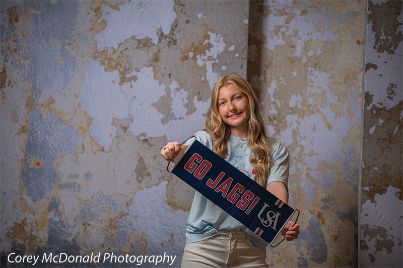 Caspian Silver and Beige Weathered Texture, photography backdrop panel for Denny StudioEdge silicone edge frame, shown with a senior girl holding a Go Jags banner, full-length SECP-8856