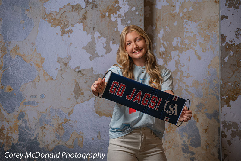 Caspian Silver and Beige Weathered Texture, photography backdrop panel for Denny StudioEdge silicone edge frame, shown with a senior girl holding a Go Jags banner SECP-8856
