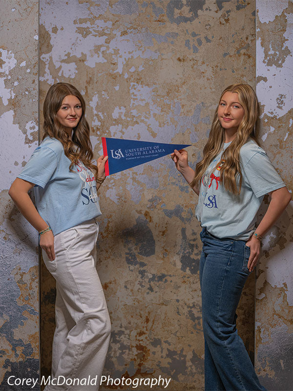 Caspian Silver and Beige Weathered Texture, photography backdrop panel for Denny StudioEdge silicone edge frame, shown with two senior girls in matching tees holding a University of South Alabama pennant SECP-8856