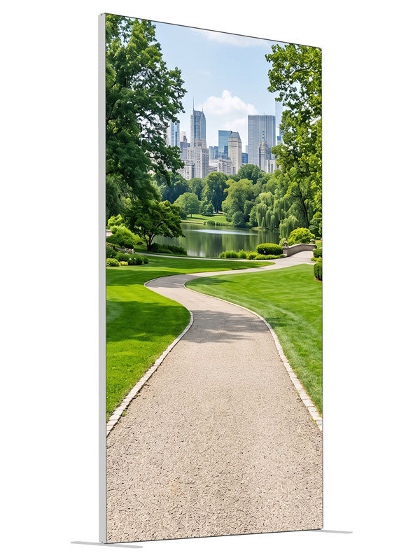 A landscaped city park with a winding gravel path, lake and flower borders below a distant skyline, 4ft photography backdrop panel for Denny StudioEdge silicone edge frame, angled view