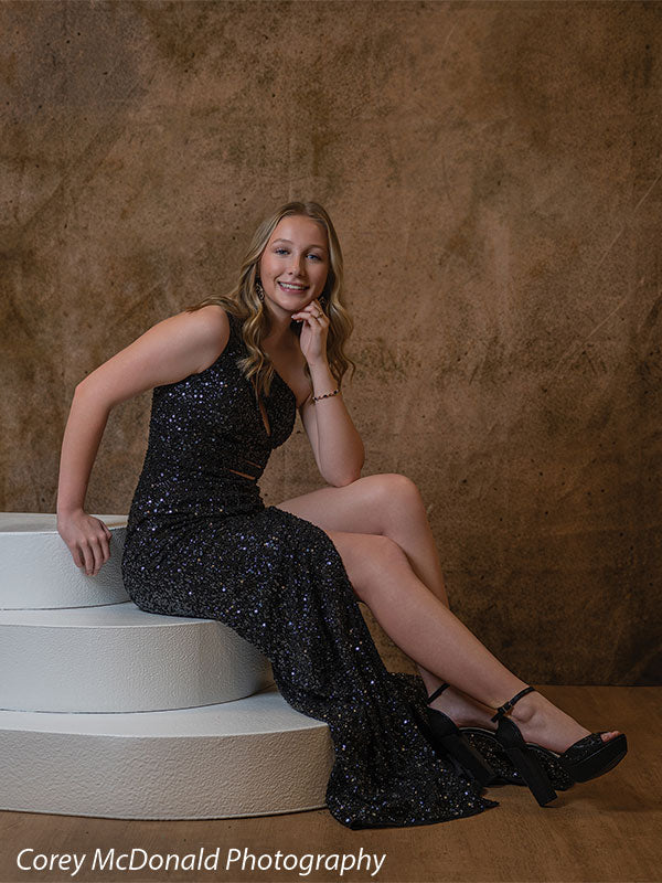 Corner Steps posing prop shown with a senior girl in a black sequin gown seated on the white foam corner steps smiling in a vertical portrait Cor-Step