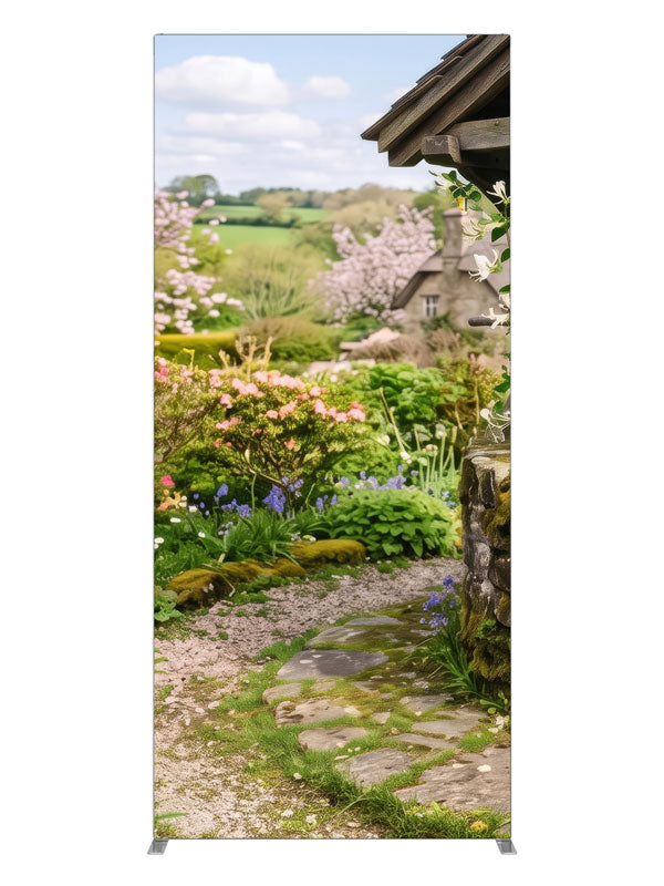 A spring cottage garden with a stone wishing well, a flowering path and a cottage with green hills, 3ft photography backdrop panel for Denny StudioEdge silicone edge frame