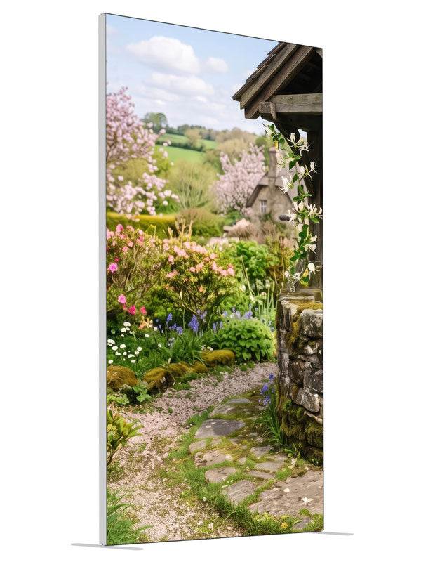 A spring cottage garden with a stone wishing well, a flowering path and a cottage with green hills, 4ft photography backdrop panel for Denny StudioEdge silicone edge frame, angled view