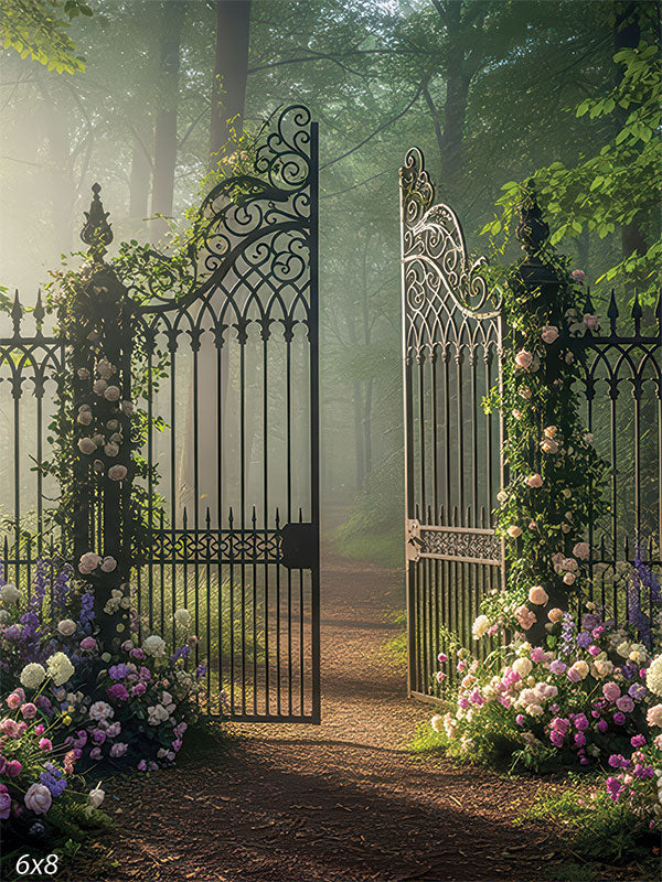 A partly open wrought-iron gate draped in roses stands before a misty woodland path with dappled sunlight.
