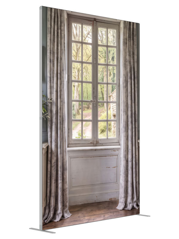 A pale blue-gray French country room with a window onto a spring garden and stone cottage, 5ft photography backdrop panel for Denny StudioEdge silicone edge frame, angled view