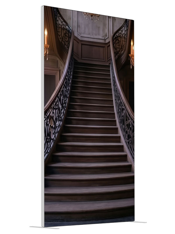 An opulent mansion foyer staircase with iron scroll railings and lit crystal chandeliers, 4ft photography backdrop panel for Denny StudioEdge silicone edge frame, angled view