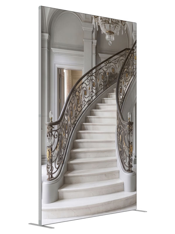 A grand curved gray marble staircase with bronze-and-gold iron railings and a crystal chandelier, 5ft photography backdrop panel for Denny StudioEdge silicone edge frame, angled view