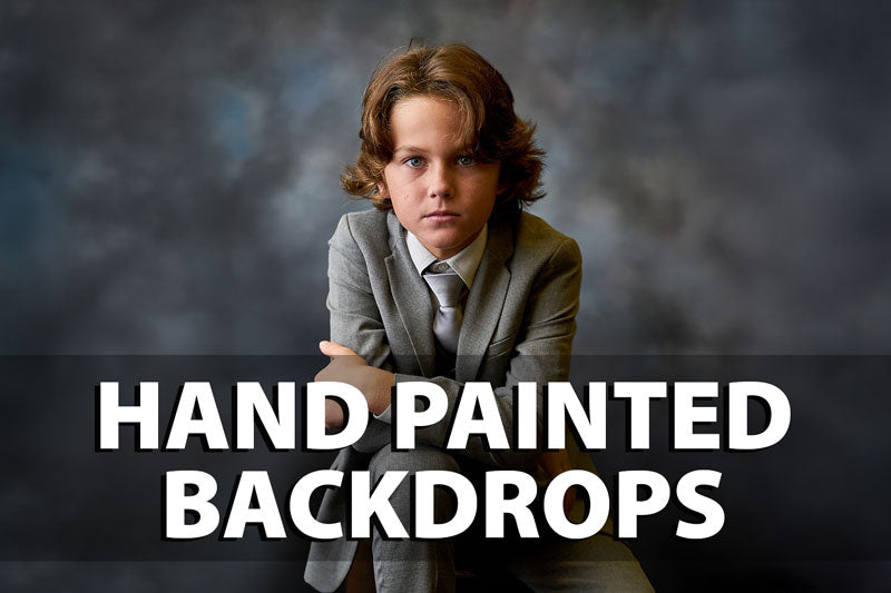 Hand painted photography backdrop with textured gray and blue tones, shown behind a boy in a suit, perfect for studio portrait sessions seeking a classic painted background.