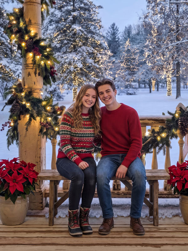 Heirloom Porch snow-covered porch with lit garland photography backdrop shown with a teen couple seated together on a wooden bench CP-8878