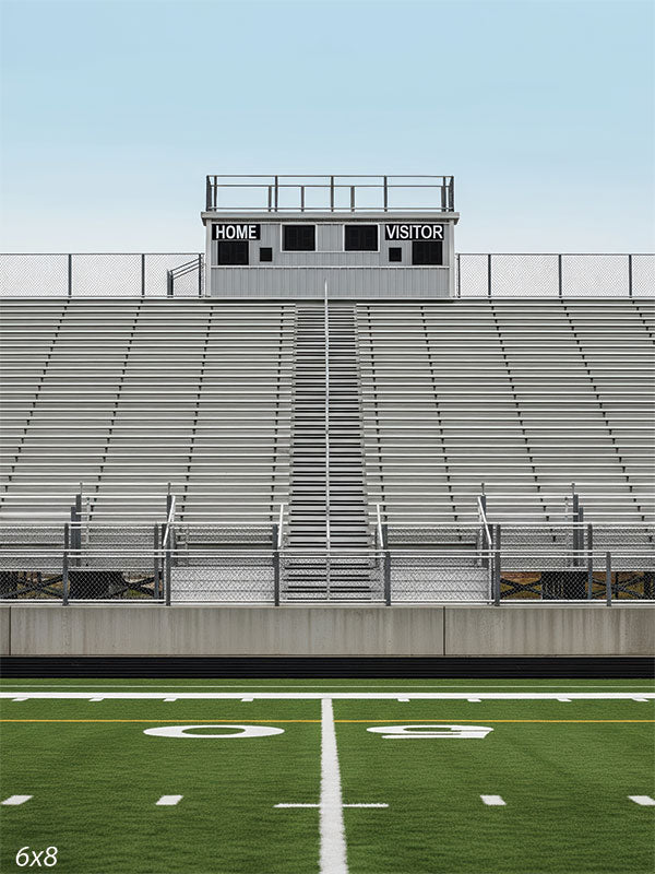 Wide silver bleachers and bright turf field create a clean, symmetrical sports scene perfect for senior athlete portraits.