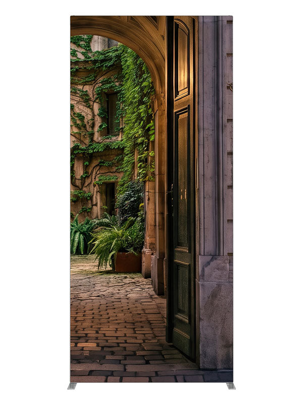 Stone archway opening onto an ivy-covered European courtyard with a glowing iron street lamp, 3ft photography backdrop panel for Denny StudioEdge silicone edge frame