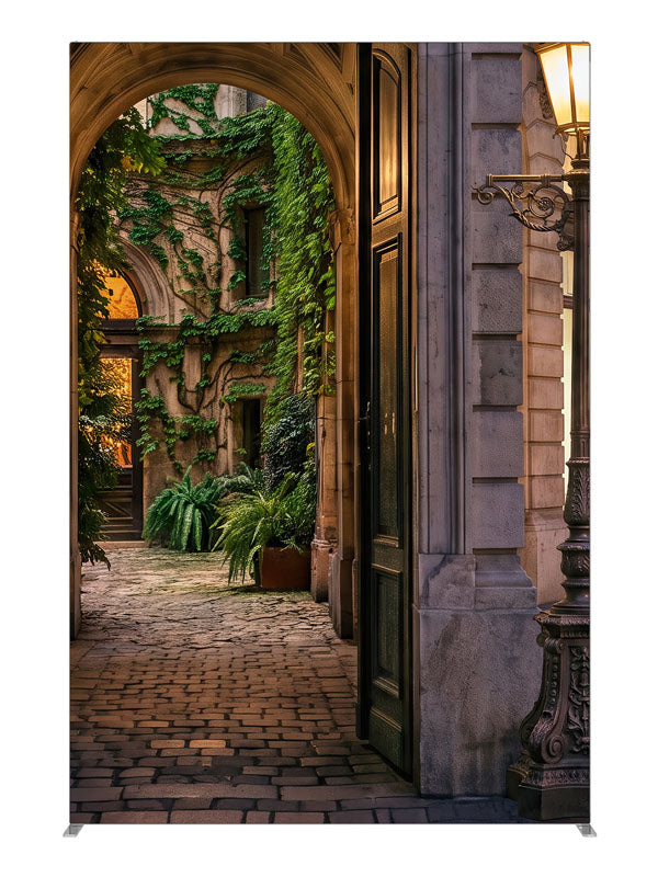 Stone archway opening onto an ivy-covered European courtyard with a glowing iron street lamp, 5ft photography backdrop panel for Denny StudioEdge silicone edge frame