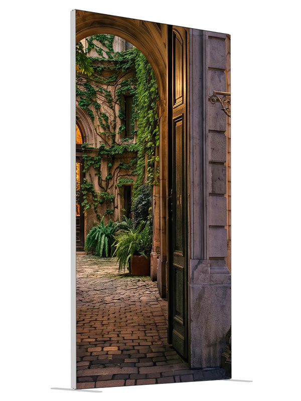 Stone archway opening onto an ivy-covered European courtyard with a glowing iron street lamp, 4ft photography backdrop panel for Denny StudioEdge silicone edge frame, angled view