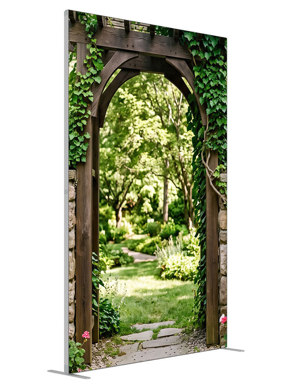Dark timber and dry-stacked stone garden arbor under heavy ivy opening onto a sunlit lawn, 5ft photography backdrop panel for Denny StudioEdge silicone edge frame, angled view