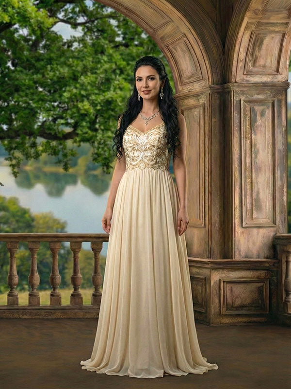 A woman with long dark hair stands beneath a stone arch balcony backdrop with carved columns and trailing ivy, overlooking a peaceful lake and lush green trees, wearing a cream-colored embroidered gown with a flowing skirt and jewelry, facing forward with a relaxed posture.