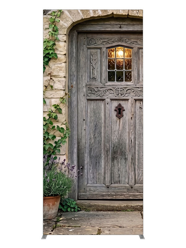 Arched weathered plank cottage door in a honey stone wall with climbing ivy, lavender and potted hydrangeas, 3ft photography backdrop panel for Denny StudioEdge silicone edge frame