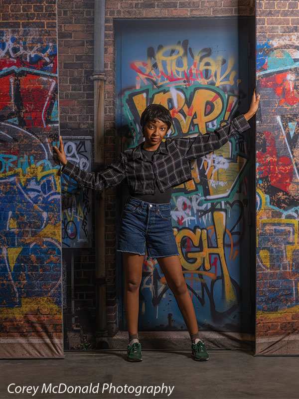 Keaton Graffiti Warehouse Door, photography backdrop panel for Denny StudioEdge silicone edge frame, shown with a senior girl with both arms spread against the graffiti warehouse door SECP-8864