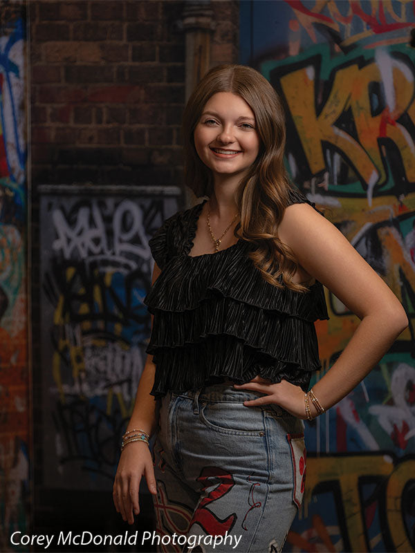 Keaton Graffiti Warehouse Door, photography backdrop panel for Denny StudioEdge silicone edge frame, shown with a senior girl in a black ruffle top with a hand on her hip, smiling SECP-8864