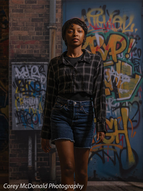 Keaton Graffiti Warehouse Door, photography backdrop panel for Denny StudioEdge silicone edge frame, shown with a senior girl standing centered against the graffiti warehouse door, half-length SECP-8864