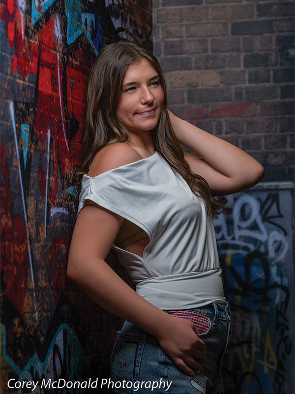 Keaton Graffiti Warehouse Door, photography backdrop panel for Denny StudioEdge silicone edge frame, shown with a senior girl in an off-shoulder white top with a hand behind her neck SECP-8864