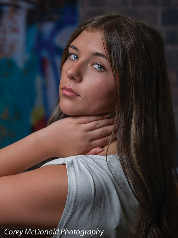 Keaton Graffiti Warehouse Door, photography backdrop panel for Denny StudioEdge silicone edge frame, shown with a senior girl in an off-shoulder white top in a close portrait with a hand at her neck SECP-8864