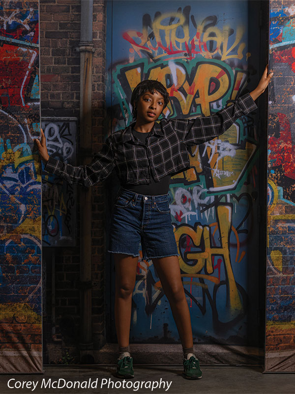 Keaton Graffiti Warehouse Door, photography backdrop panel for Denny StudioEdge silicone edge frame, shown with a senior girl with one arm raised against the graffiti warehouse door SECP-8864