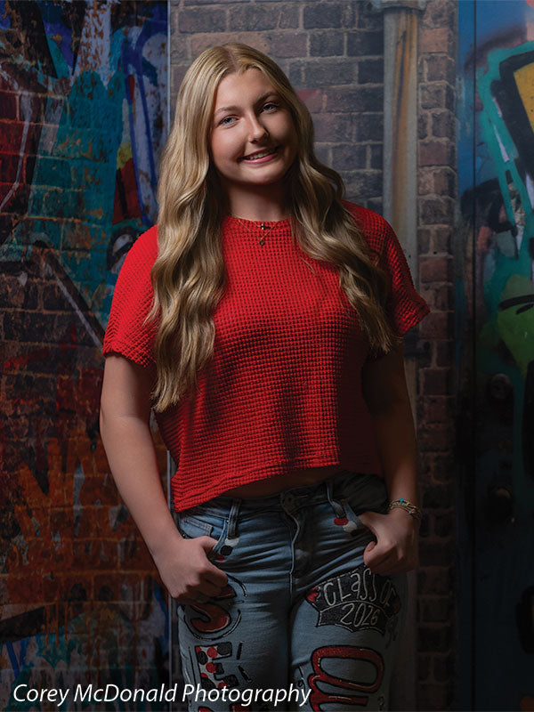 Keaton Graffiti Warehouse Door, photography backdrop panel for Denny StudioEdge silicone edge frame, shown with a senior girl in a red top smiling with hands in her pockets SECP-8864